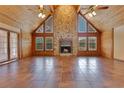 Open living room with a stone fireplace, wood-paneled walls and ceilings, and lots of natural light at 5180 Garlanger Trl, Oviedo, FL 32765
