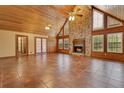 Open living room features a stone fireplace, high ceilings, tile floors, and plenty of natural light at 5180 Garlanger Trl, Oviedo, FL 32765