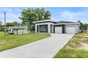 Contemporary home with a spacious driveway and a well-manicured lawn at 5438 Brownell St, Orlando, FL 32810