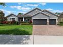 Inviting single-Gathering home featuring a three-car garage and beautifully landscaped front yard at 595 American Holly Pl, Oviedo, FL 32765