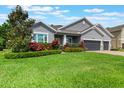 Beautiful single-Gathering home featuring lush green lawn and vibrant landscaping in a well-maintained yard at 595 American Holly Pl, Oviedo, FL 32765