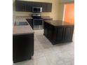 Well-equipped kitchen featuring stainless steel appliances, a central island, and a sink with stylish faucet at 701 Twin Lake Ave, Deltona, FL 32738