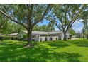 Attractive home with a large, green front yard, mature trees, and a welcoming facade at 711 Valencia Ct, Winter Garden, FL 34787