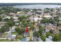 Aerial view of the home and neighborhood with mature trees and a lake in the distance at 814 Jefferson Ave, Lakeland, FL 33801