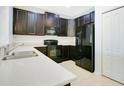 Modern kitchen featuring black appliances, dark cabinetry, and sleek countertops at 9069 Shepton St, Orlando, FL 32825