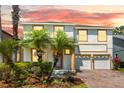 Two-story home featuring brick driveway, palm trees, well-kept lawn, and a convenient two-car garage at 9836 Old Patina Way, Orlando, FL 32832
