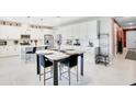 Bright kitchen with white cabinetry, stainless steel appliances, and a table with chairs, perfect for dining at 10249 Spring Lake Dr, Clermont, FL 34711