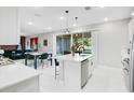 A well-lit kitchen featuring an island with seating and a view of the adjacent dining and living areas at 10249 Spring Lake Dr, Clermont, FL 34711