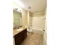 Cozy bathroom featuring a granite vanity, and a shower-tub combination with tile flooring at 10506 Green Ivy Lane, Orlando, FL 32832