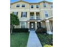 Inviting three-story townhome with a well-maintained lawn and charming front walkway, complete with a small balcony at 10506 Green Ivy Lane, Orlando, FL 32832