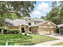 Charming two-story home with a well-maintained lawn, mature trees and a two car garage at 10664 Spring Buck Trl, Orlando, FL 32825