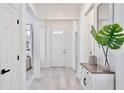 Bright entryway featuring light wood floors, white walls, and a decorative table creating an open, airy feel at 1101 Rush Ct, Celebration, FL 34747