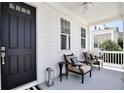 Inviting front porch with neutral chairs, a black door, and views of the serene neighborhood at 1101 Rush Ct, Celebration, FL 34747