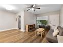 Bright living room features wood flooring, modern ceiling fan, comfortable seating, and natural light from large window at 1140 S Orlando Ave # E11, Maitland, FL 32751