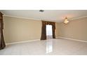 Bright living room with tile flooring, elegant chandelier, and large window with decorative curtains at 115 Bristol Forest Trl, Sanford, FL 32771