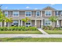 Charming two-story townhome featuring a well-manicured lawn and inviting front porch, perfect for relaxing outdoors at 11574 Buoy Point Pl, Orlando, FL 32832