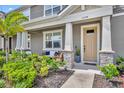 Inviting front porch featuring stone columns, cozy seating, and well-maintained landscaping for relaxing and enjoying the outdoors at 11574 Buoy Point Pl, Orlando, FL 32832