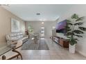 Inviting living room boasts tile floors, neutral paint, and an open floor plan to the dining area at 11631 Mystery Ln, Orlando, FL 32832