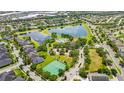 This aerial view shows neighborhood amenities include a pool, playground, tennis courts, and a scenic lake at 12917 Grovehurst Ave, Winter Garden, FL 34787
