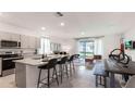 Open concept kitchen with granite countertops, stainless steel appliances, and an island with barstool seating at 1300 Isleta Loop, Kissimmee, FL 34741