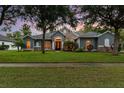 Charming home featuring stone accents, arched windows and lush green lawn at 1333 Killbricken Cir, Ormond Beach, FL 32174