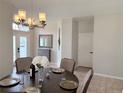 Dining room features a chandelier, a dark wood table with chairs, and views of the home's entry area at 14400 Saint Georges Hill Dr, Orlando, FL 32828