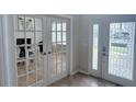 Bright foyer featuring decorative glass doors leading to an office space with tiled floors and neutral walls at 14400 Saint Georges Hill Dr, Orlando, FL 32828
