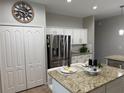 Spacious kitchen featuring stainless steel refrigerator and granite countertops at 14400 Saint Georges Hill Dr, Orlando, FL 32828