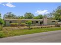 A quaint single-story home with a well-manicured front lawn and traditional design at 1491 Granada Ave, Daytona Beach, FL 32117