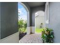 A peaceful front porch with natural stone tiles and decorative foliage at 1553 Caterpillar St, St Cloud, FL 34771