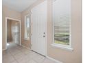 Bright foyer with tile flooring, white trim, and natural light streaming through the windows at 1610 Mohegan Blvd, Kissimmee, FL 34744