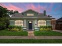Charming green bungalow at twilight, with an inviting entrance, and manicured landscaping at 1625 S Eola Dr, Orlando, FL 32806