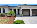 Inviting home exterior highlighting a two-car garage, stone accents, and landscaped garden with a paved walkway at 1821 Windsor Dr, Winter Park, FL 32789