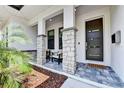 Welcoming front porch with stone pillars, stylish seating, and a contemporary front door, creating curb appeal at 1821 Windsor Dr, Winter Park, FL 32789