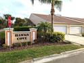 Hawks Cove community sign with a beautifully landscaped entrance and tan condos at 2299 Hawks Cove Cir, New Smyrna Beach, FL 32168