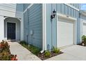 Townhome exterior displaying the front door, a one-car garage, and fresh landscaping at 2949 Clever Ln, Winter Park, FL 32792