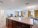 Open-concept kitchen with island and view of the living and dining areas at 3216 Casa Del Rey Ave, Kissimmee, FL 34746
