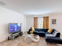 Comfortable living room with a cozy blue sectional sofa and a glass coffee table at 3216 Casa Del Rey Ave, Kissimmee, FL 34746