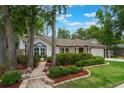 Lovely one-story home with manicured landscaping, a stone walkway, and an attached two-car garage at 352 Inglenook Cir, Winter Springs, FL 32708