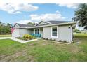 Gray home with blue chairs and a cute blue door at 38 Malauka Dr, Ocklawaha, FL 32179