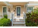 Inviting front entrance with decorative door, trimmed with green landscaping, and bright white posts and trim at 415 Old Farm Ln, Winter Springs, FL 32708