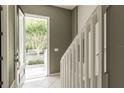Bright entryway featuring a view of the front yard, light tile floors, and a staircase at 415 Old Farm Ln, Winter Springs, FL 32708