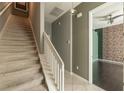 Staircase leading to upper level, complemented by neutral walls and a view of the adjacent room at 415 Old Farm Ln, Winter Springs, FL 32708