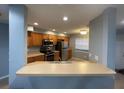 Kitchen features stainless steel appliances, oak cabinets, and a pass-through bar to the living room at 4503 Oak Arbor Cir, Orlando, FL 32808