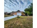 A quaint one-story home, featuring a light orange color and a lengthy driveway to the two car garage at 4840 Judy Ann Ct, Orlando, FL 32808