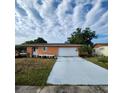 Charming single-story home with a long driveway and an attached two-car garage at 4840 Judy Ann Ct, Orlando, FL 32808