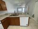 Kitchen with stainless steel sink, wooden cabinetry, and white appliances at 514 Wilton Cir, Sanford, FL 32773