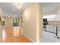 Open-concept living room with hardwood flooring, sliding glass doors, and a glimpse into the kitchen at 609 Northbridge Dr, Altamonte Springs, FL 32714
