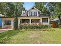 Quaint two-story home with well-maintained lawn, colorful plants, and an attached carport at 641 E Livingston St, Orlando, FL 32803
