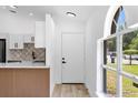 Bright foyer with light wood floors, complemented by a window and kitchen view at 6856 Ebans Bend, Orlando, FL 32807